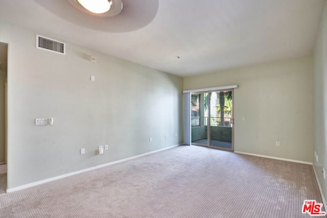 spare room featuring light carpet