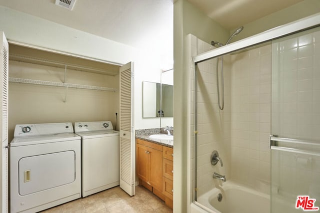 laundry room featuring light tile patterned floors, separate washer and dryer, and sink