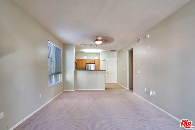 unfurnished living room featuring light carpet