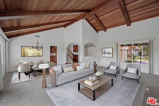 carpeted living room featuring beamed ceiling, high vaulted ceiling, an inviting chandelier, and wood ceiling