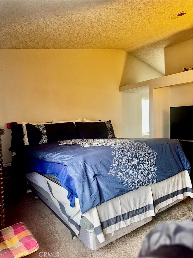 bedroom featuring a textured ceiling and carpet floors