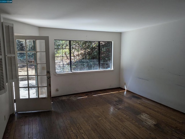 unfurnished room with dark hardwood / wood-style flooring