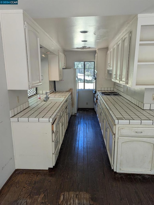 kitchen with white cabinets, tile counters, and dark hardwood / wood-style flooring