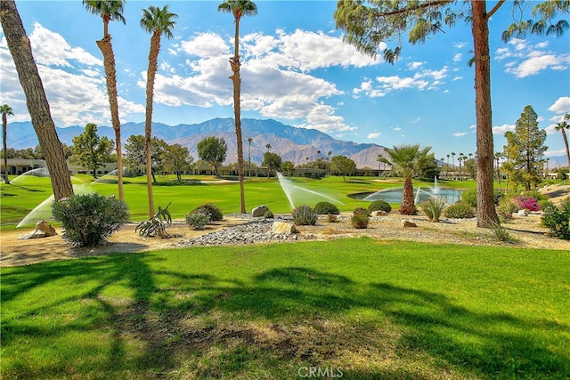 surrounding community with a mountain view and a lawn