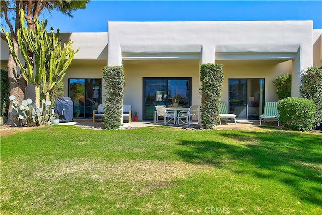 rear view of property with a patio and a yard