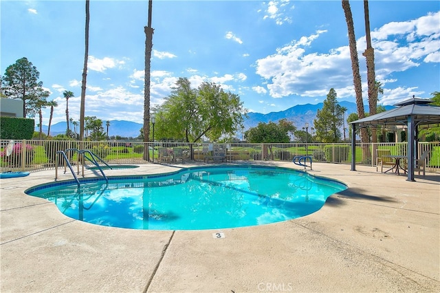 view of swimming pool with a gazebo, a mountain view, and a patio area