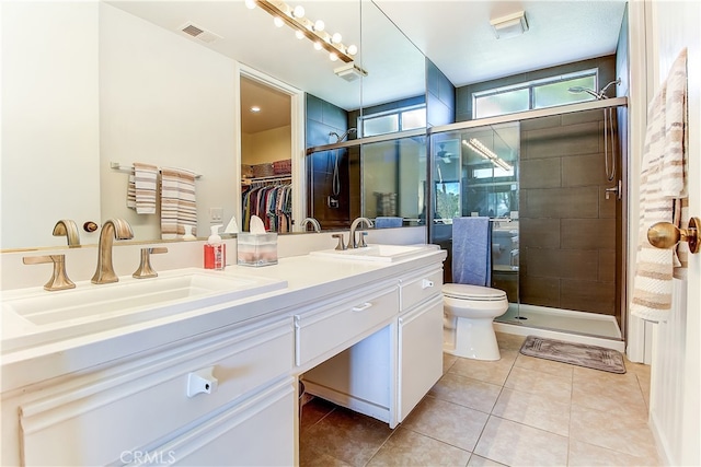 bathroom with vanity, a shower with shower door, toilet, and tile patterned flooring