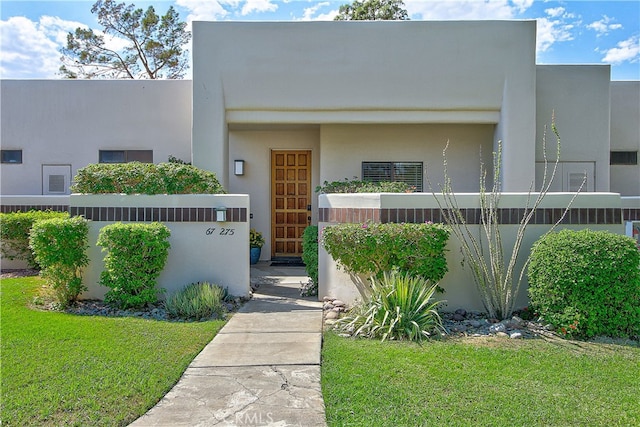 entrance to property with a lawn