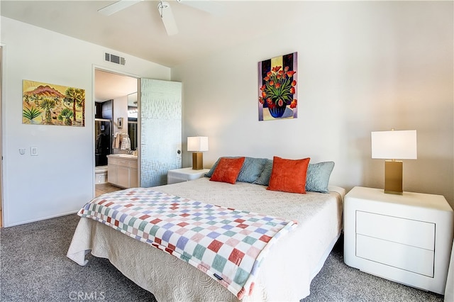 carpeted bedroom with ceiling fan and ensuite bath