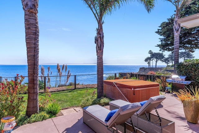 view of patio featuring a water view and a hot tub