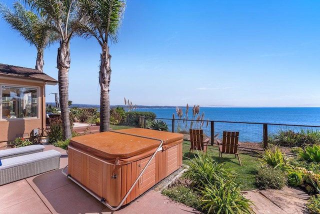 view of patio with a water view and a hot tub