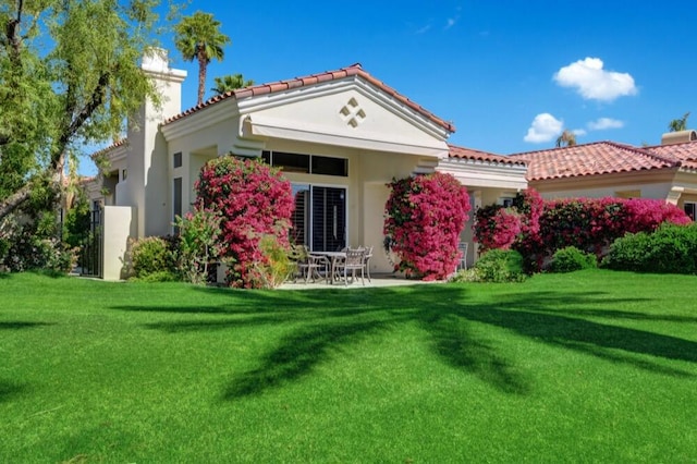 back of house featuring a yard and a patio area