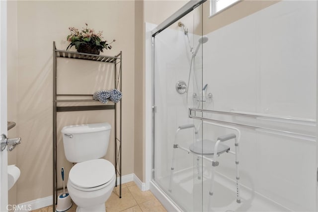 bathroom with tile patterned flooring, an enclosed shower, and toilet