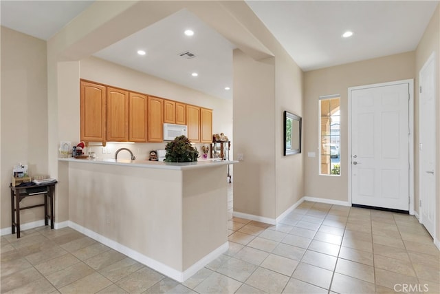 kitchen with kitchen peninsula and light tile patterned floors