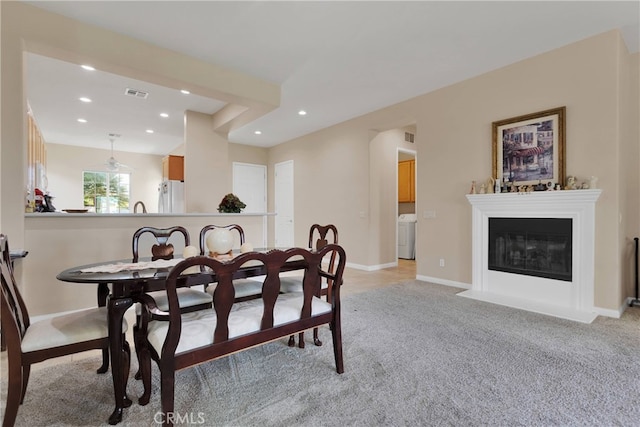 carpeted dining room featuring washer / dryer