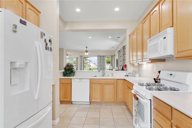 kitchen with light tile patterned floors, light brown cabinets, sink, and white appliances