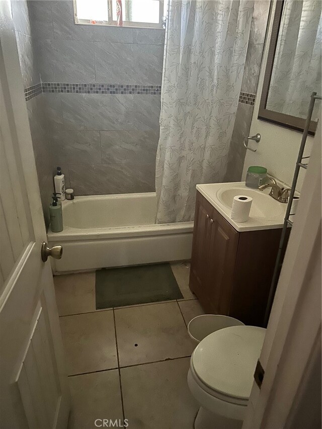 full bathroom with tile patterned flooring, shower / bath combo, vanity, and toilet