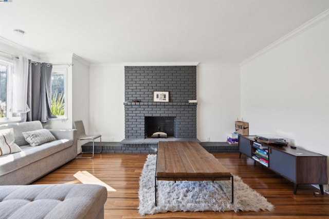 living room featuring ornamental molding, dark hardwood / wood-style floors, and a brick fireplace