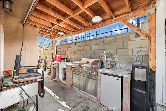 view of patio with area for grilling and sink