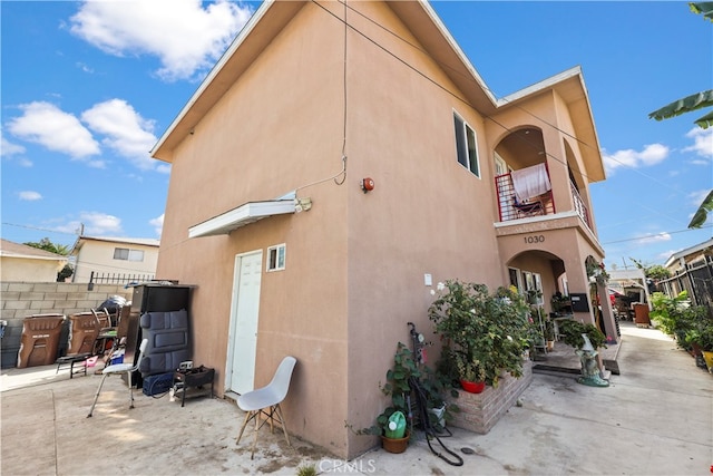 rear view of property with a balcony and a patio