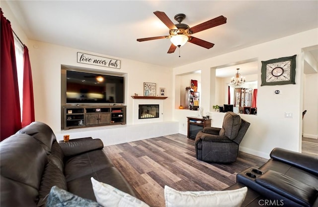 living room featuring wood-type flooring and ceiling fan with notable chandelier