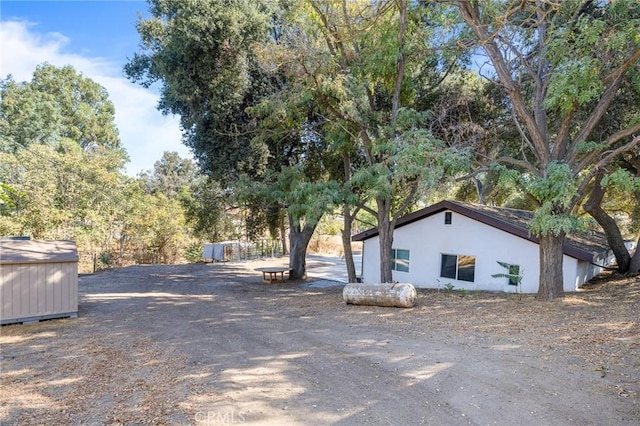 24120 Manzanita St, Menifee, CA 92584 - view of side of home featuring an outdoor structure, stucco siding, and a storage unit