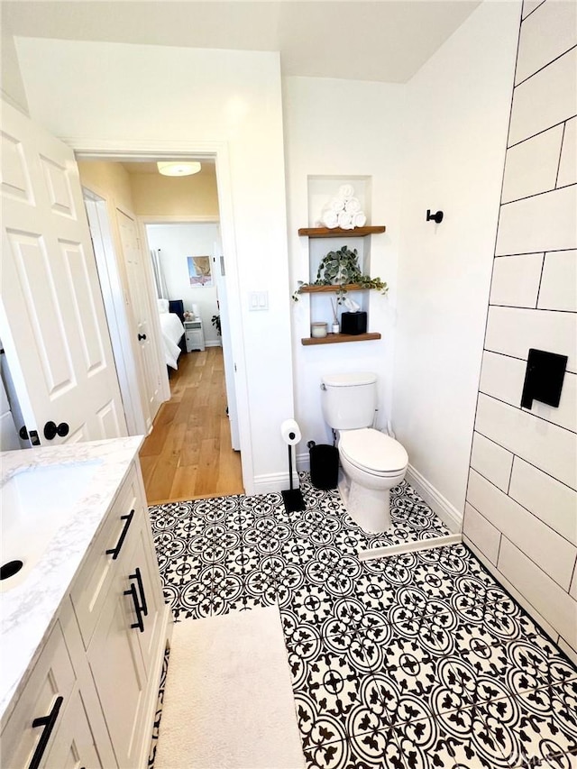 bathroom with tile patterned flooring, vanity, and toilet