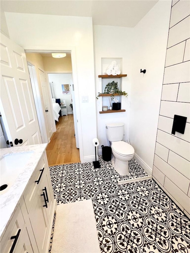 bathroom with tile patterned floors, vanity, toilet, and baseboards