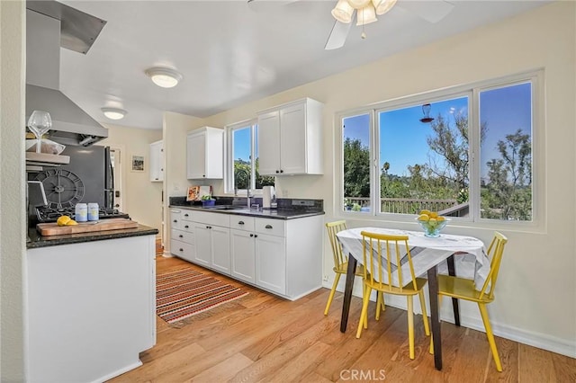 kitchen featuring white cabinetry, light hardwood / wood-style flooring, ceiling fan, and sink