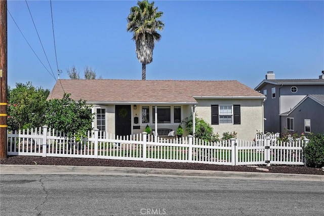 view of front of home with a fenced front yard and stucco siding