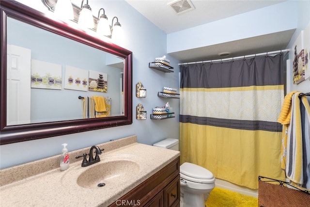 bathroom with vanity, a shower with shower curtain, and toilet