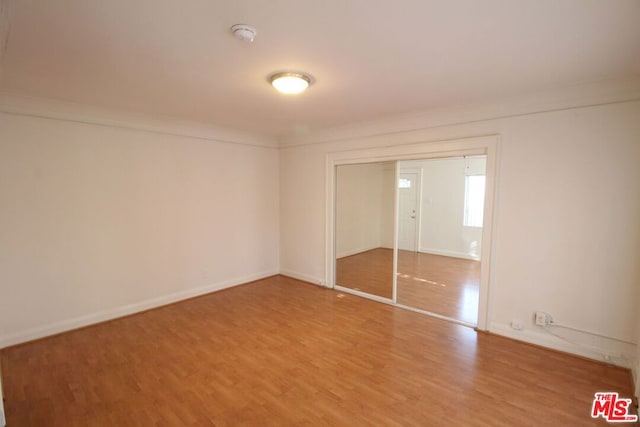 unfurnished bedroom featuring a closet and hardwood / wood-style flooring