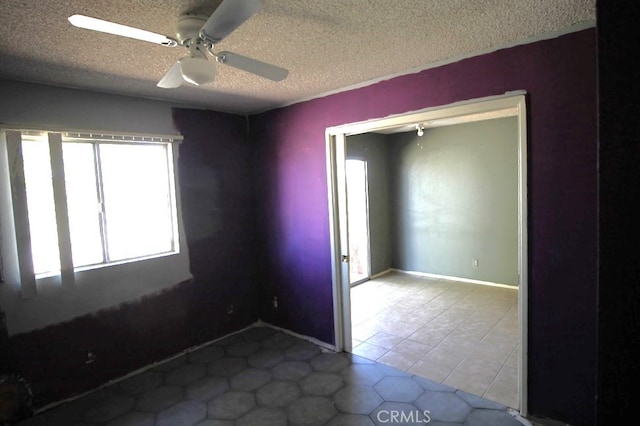 unfurnished room featuring light tile patterned flooring, ceiling fan, and a textured ceiling