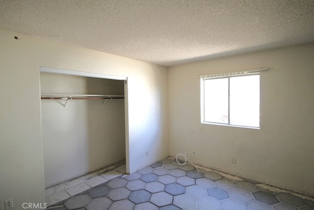 unfurnished bedroom with a closet and a textured ceiling