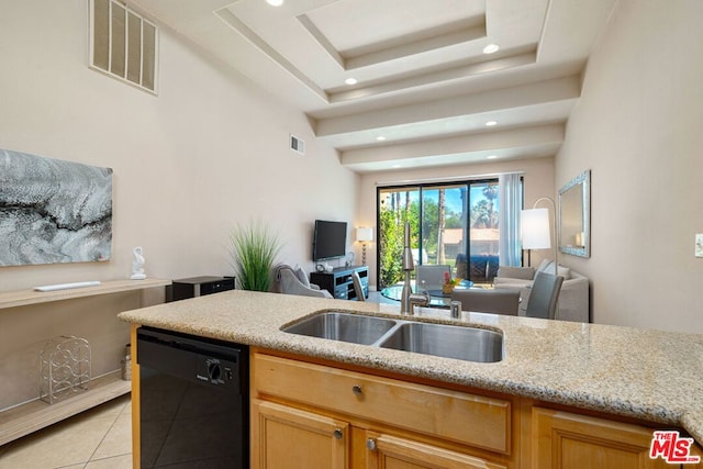 kitchen featuring black dishwasher, sink, light tile patterned floors, and a tray ceiling