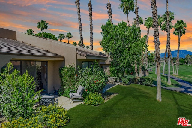 exterior space with a mountain view, a patio, and a lawn