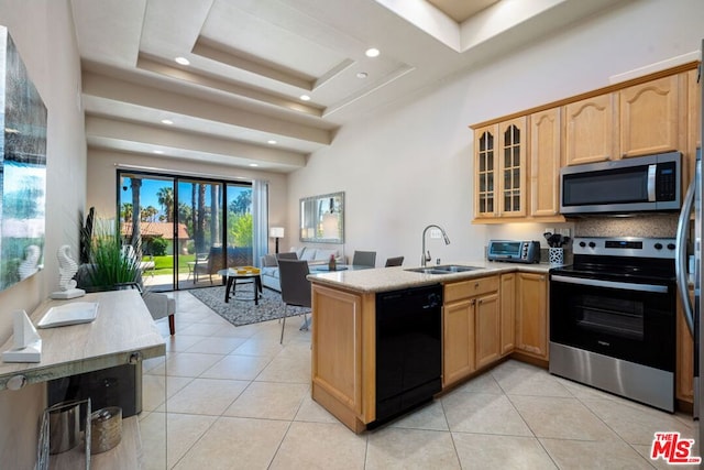 kitchen featuring appliances with stainless steel finishes, kitchen peninsula, light tile patterned floors, and a raised ceiling