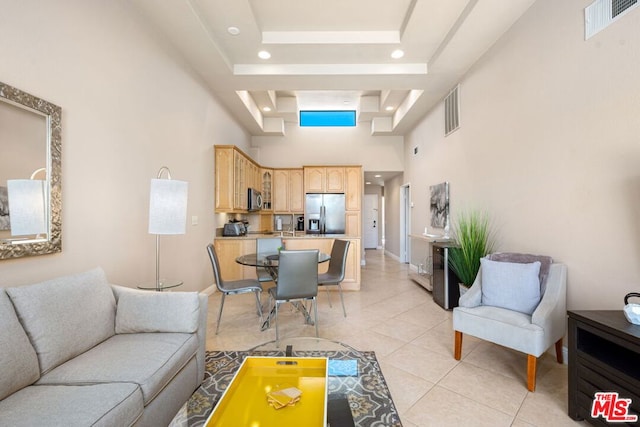 tiled living room with a tray ceiling and a high ceiling