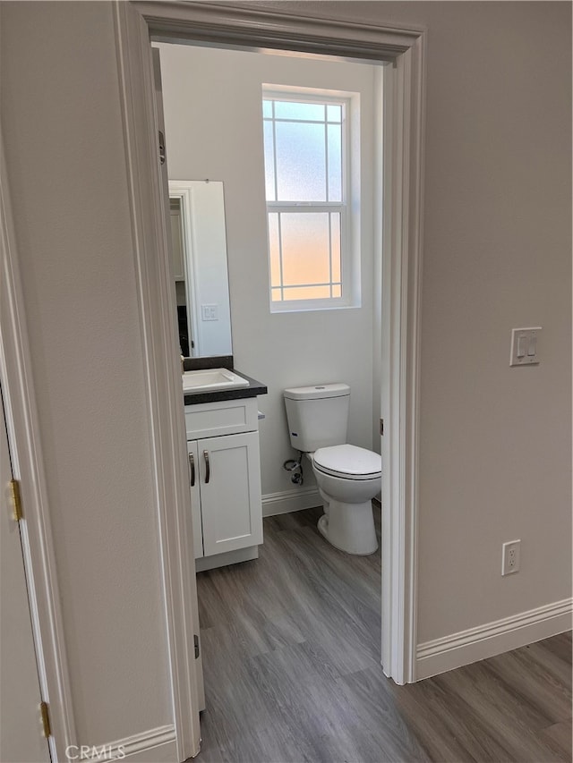 bathroom featuring wood-type flooring, vanity, and toilet