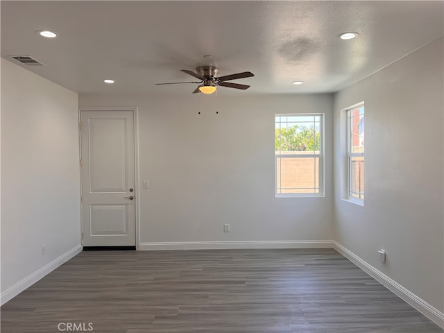 empty room featuring ceiling fan, a textured ceiling, and dark wood-type flooring