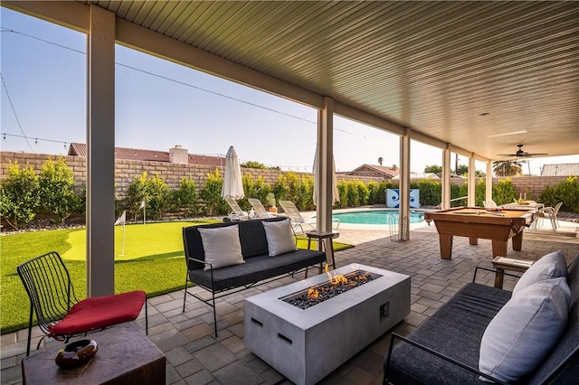 view of patio featuring a fenced in pool and an outdoor living space with a fire pit