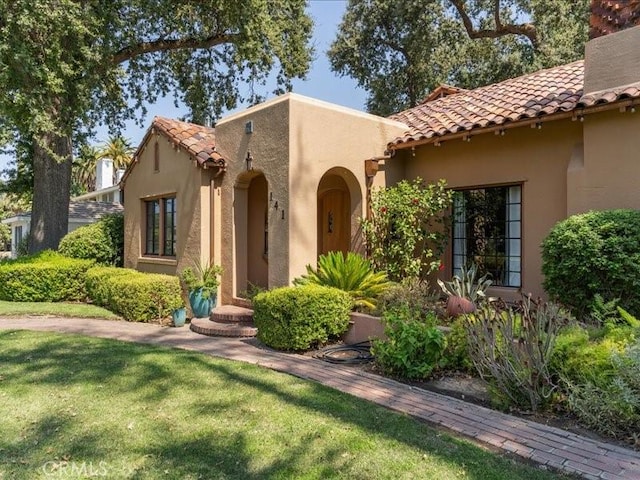 mediterranean / spanish-style home with a front yard