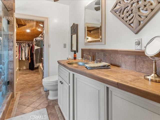 bathroom featuring vanity, decorative backsplash, wood ceiling, and toilet