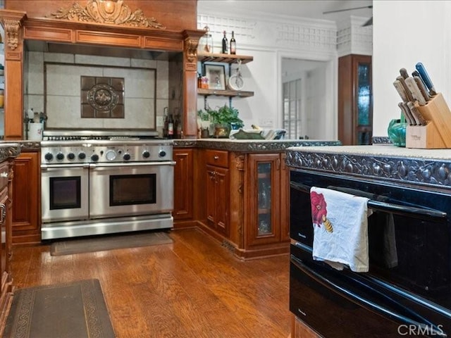 kitchen featuring hardwood / wood-style floors, tasteful backsplash, double oven range, range, and crown molding