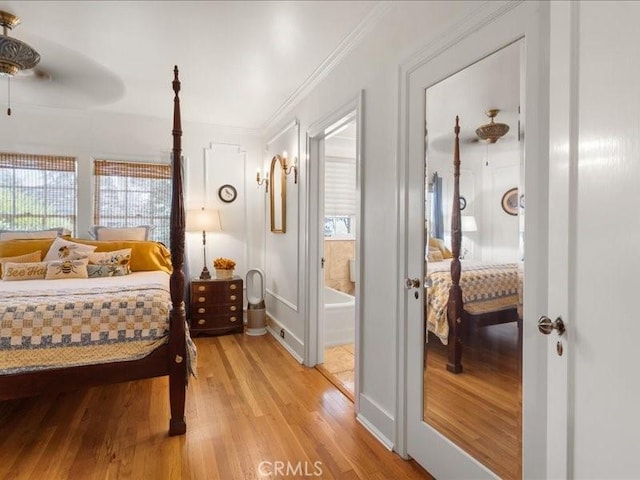 bedroom with ornamental molding, connected bathroom, and light hardwood / wood-style floors