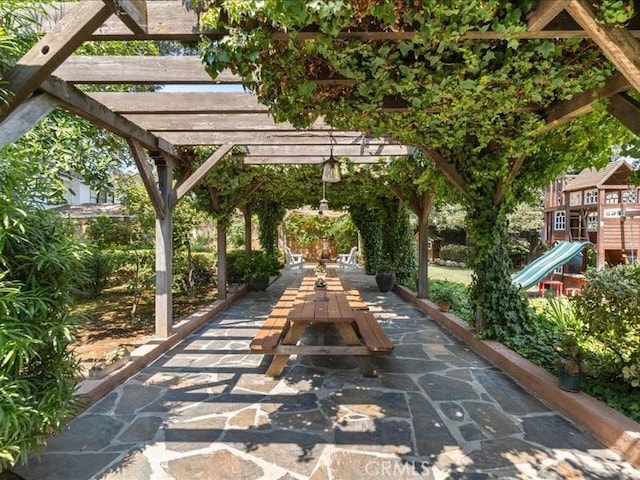 view of home's community featuring a playground, a patio, and a pergola