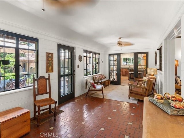 living area with french doors, ceiling fan, and plenty of natural light