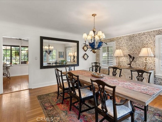 dining space featuring wood-type flooring and a notable chandelier