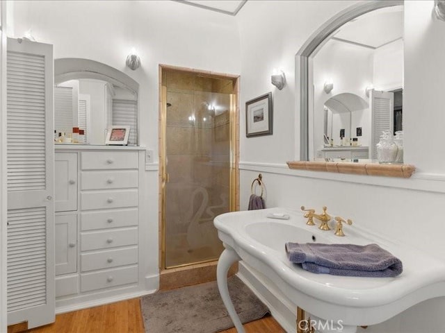 bathroom with hardwood / wood-style flooring and walk in shower