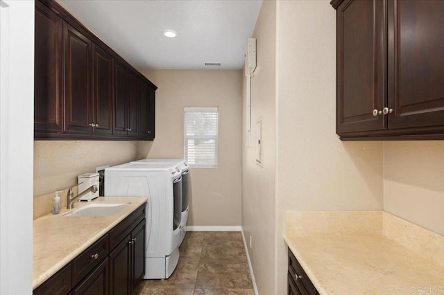 laundry area with washing machine and dryer, sink, and cabinets